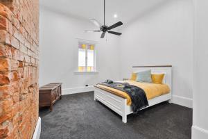 a bedroom with a bed and a ceiling fan at The Bank House Ulmarra in Ulmarra