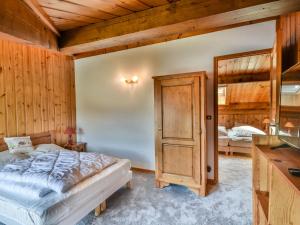 ein Schlafzimmer mit einem Bett in einem Zimmer mit Holzwänden in der Unterkunft Appartement Les Gets, 3 pièces, 6 personnes - FR-1-685-35 in Les Gets