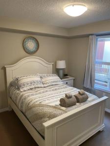 a bedroom with a white bed with towels on it at Chris's Cozy Condo Times Square Rogers Place Edmonton in Edmonton