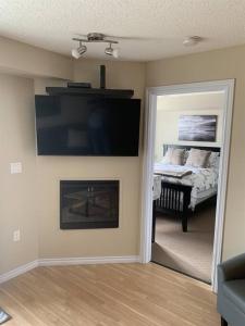 a room with a fireplace and a bedroom with a bed at Chris's Cozy Condo Times Square Rogers Place Edmonton in Edmonton