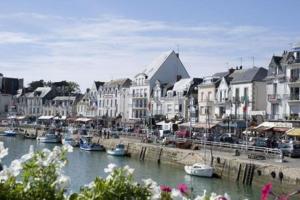 a group of boats in a river with buildings at Bord de mer proche du port 500m de La Baule in Le Pouliguen