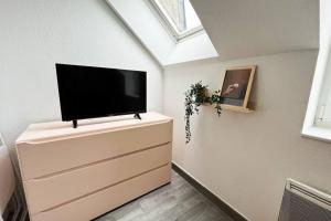 a flat screen tv on a dresser in a room at Bord de mer proche du port 500m de La Baule in Le Pouliguen