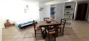 Habitación con cama, mesa y sillas. en Casa di GiAde en Anguillara Sabazia