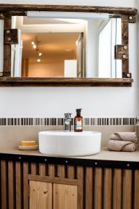 y baño con lavabo y espejo. en Le lavandin, spacieux et moderne P4, centre ville, wifi, en Nimes