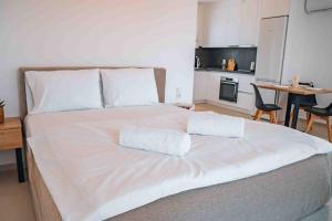 a large white bed with two white pillows on it at Grand White Apartments in Agios Ioannis