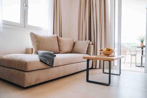 a living room with a couch and a table at Grand White Apartments in Agios Ioannis