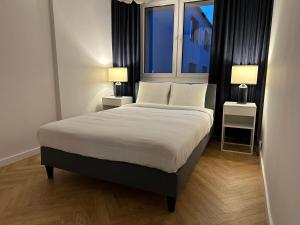 sypialnia z dużym łóżkiem z 2 lampami i oknem w obiekcie Mały Kwadrat Katowice w mieście Katowice