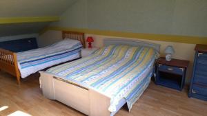 een slaapkamer met twee bedden en twee nachtkastjes bij La Bourgandie in Englesqueville-la-Percée