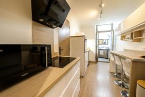 cocina con electrodomésticos blancos y encimera en Le lavandin, spacieux et moderne P4, centre ville, wifi, en Nimes