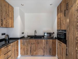 a kitchen with wooden cabinets and a sink at Appartement Courchevel 1850, 4 pièces, 6 personnes - FR-1-564-91 in Courchevel