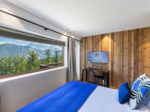 Appartement Courchevel 1850, 4 pièces, 6 personnes - FR-1-564-91 في كورشوفيل: غرفة نوم بسرير ازرق ونافذة