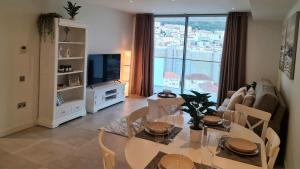 ジブラルタルにあるLuxury Apartment in Eurocityのリビングルーム(ダイニングテーブル、テレビ付)