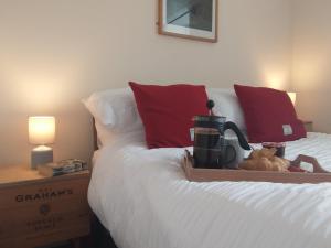 a bedroom with a bed with a coffee maker on it at Snowberry Cottage in Borve