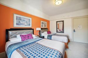 two beds in a hotel room with orange walls at Union Square Plaza Hotel in San Francisco