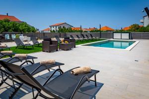 a group of chairs sitting next to a swimming pool at KM Exclusive Apartments in Zadar