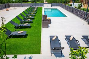 patio z krzesłami i basenem w obiekcie KM Exclusive Apartments w mieście Zadar