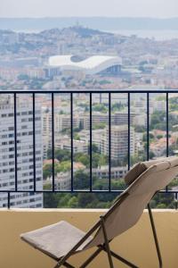 einen weißen Stuhl auf einem Balkon mit Aussicht in der Unterkunft Panoramic view of Marseille for two in Marseille