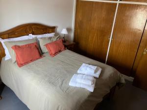 Un dormitorio con una cama grande con toallas. en Departamento General Acha, en San Juan