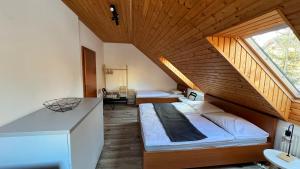 a bedroom with two beds and a wooden ceiling at SnežienkaD in Vysoké Tatry
