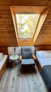 a room with two beds and a chair and a window at SnežienkaD in Vysoké Tatry