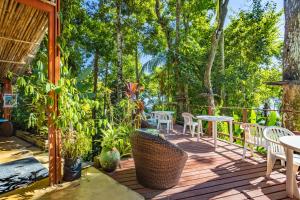 a deck with tables and chairs and trees at Pousada Lagamar in Praia Vermelha