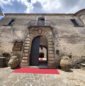 una entrada a un edificio con una alfombra roja en Relais Castello Vassallo, en Stella Cilento