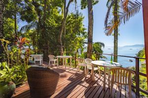 a deck with tables and chairs and a view of the ocean at Pousada Lagamar in Praia Vermelha