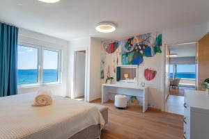 a bedroom with a bed and a desk with a view of the ocean at Apartments Mandre II in Mandre