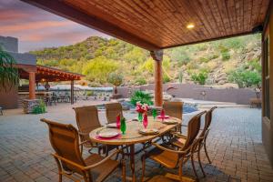 a wooden table and chairs on a patio at Quail Mountain Desert Resort: Heated Pool, Mt Vews, all BR's King & TV's, Hiking in Mesa