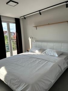 un grande letto bianco in una camera da letto con finestra di Apartments Joana a Ohrid