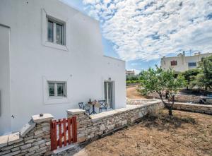 a white house with a stone retaining wall at Disis Residence in Naxos Chora