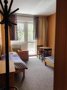 a bedroom with a bed and a table and a window at Pokoje z widokiem na Beskid Arena in Szczyrk