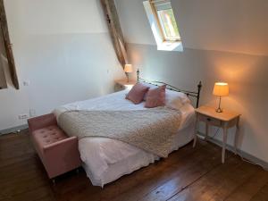 Schlafzimmer mit einem Bett mit rosa Kissen und einem Fenster in der Unterkunft Beautiful 6 bedroom house with pool & large garden in Le Pêchereau