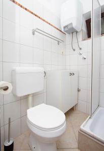 uma casa de banho branca com um WC e uma banheira em Sole e Limone em Kraj