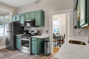 cocina con armarios verdes y fogones horno superior en Victorian Home in Mt. Washington en Pittsburgh