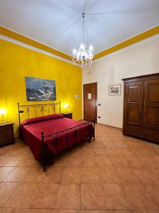 Un dormitorio con una cama roja en una habitación amarilla en Relais Castello Vassallo, en Stella Cilento