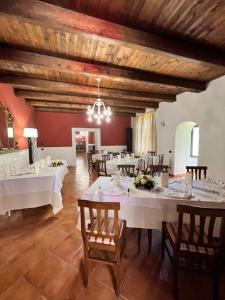 a dining room with white tables and wooden ceilings at Ospitalità Deluxe Castello Vassallo in Stella Cilento