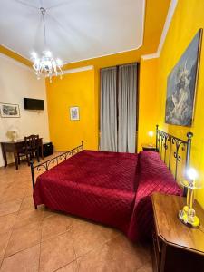 Un dormitorio con una cama roja en una habitación amarilla en Relais Castello Vassallo, en Stella Cilento