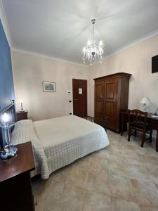 een slaapkamer met een bed en een bureau en een eetkamer bij Relais Castello Vassallo in Stella Cilento