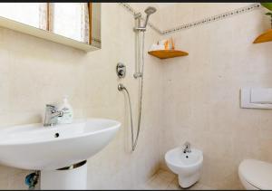 a white bathroom with a sink and a toilet at Residence Rialto in Milano Marittima