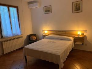 1 dormitorio con cama, silla y luces en Villino Dragonfly, en Lastra a Signa