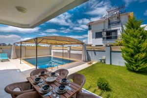 d'une terrasse avec une table et des chaises à côté de la piscine. dans l'établissement Secluded Villa with Private Pool in Antalya, à Antalya