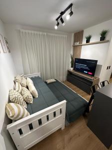 a bedroom with a large bed and a flat screen tv at New Luxury Apartments Mendoza 2 in Mendoza