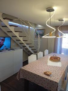uma sala de jantar com uma mesa e uma escada em espiral em CASA FASANO 