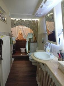 uma casa de banho com 2 WC, um lavatório e espelhos em CASA FASANO 