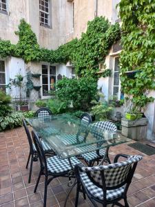 une table et des chaises en verre sur la terrasse dans l'établissement Location meublé de tourisme La Rose des Fables, à Château-Thierry