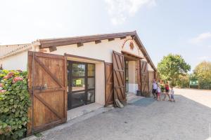 un groupe de personnes debout à l'extérieur d'un bâtiment avec des portes dans l'établissement Camping La Bergerie, à La Chapelle-Achard
