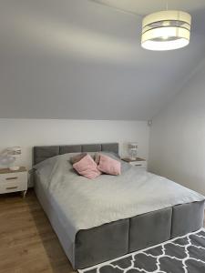 a bedroom with a large bed with two pink pillows at Domek pod lipami in Dwikozy