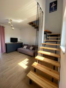 a living room with a staircase and a couch at Domek pod lipami in Dwikozy
