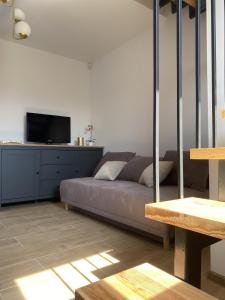 a living room with a bed and a flat screen tv at Domek pod lipami in Dwikozy